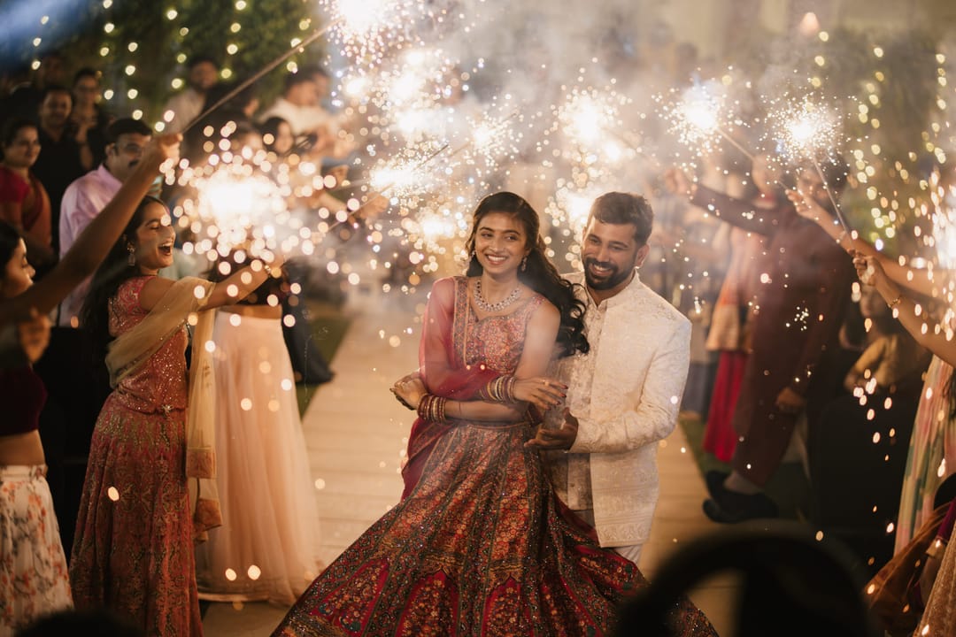 The couple dances in as guests wave sparklers around them.