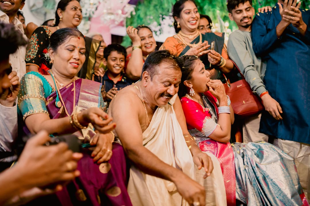 Relatives laugh and film on their phones as they watch the ceremony.